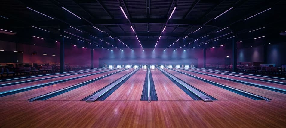 Vue cinematic d'une grande salle de bowling cosmic — 30 pistes, ambiance néon cyan violet magenta, le Bowlingstar Lyon 8 quartier Monplaisir-Bachut