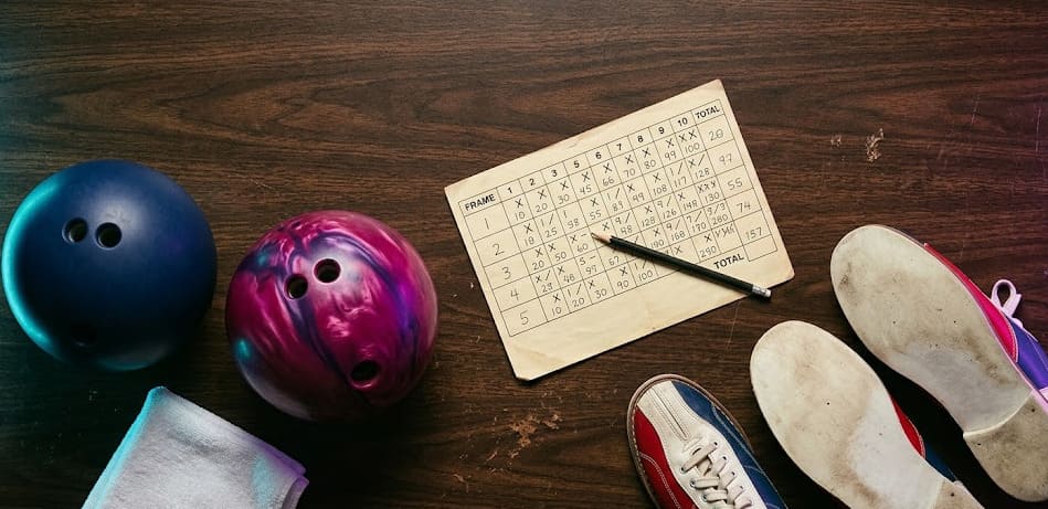 Flat lay éditorial : feuille de score, boules et chaussures de bowling