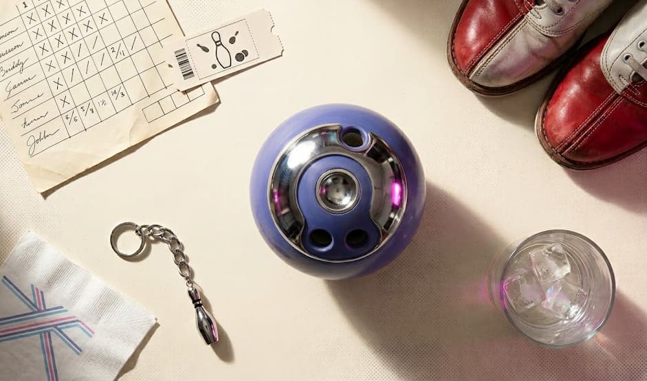 Composition flat lay éditoriale — score, ticket, boule, chaussures et accessoires d'une soirée bowling